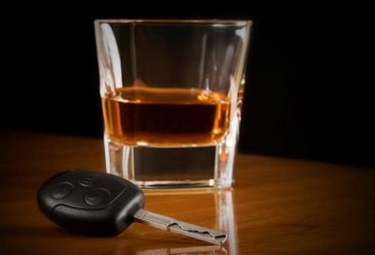 Glass of whiskey with a set of keys next to it symbolizing your ability to hire a qualified Houston DWI Lawyer